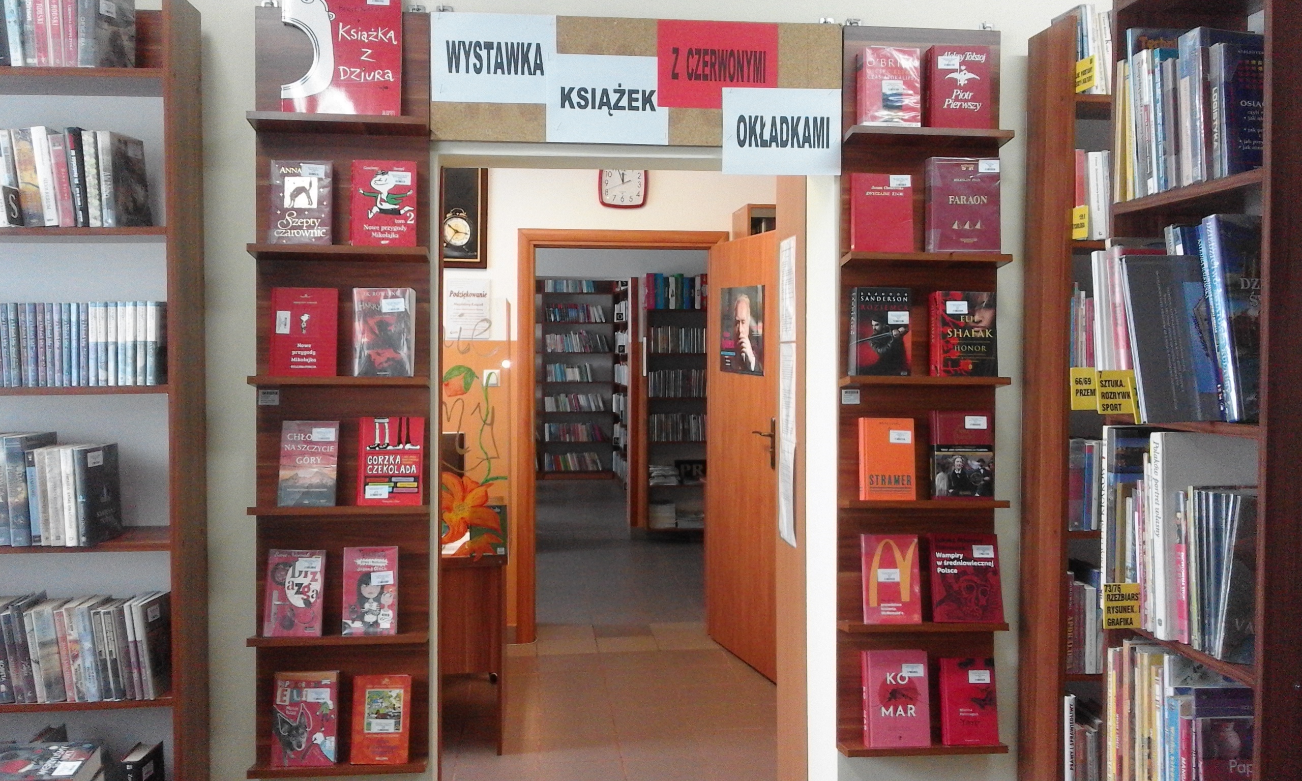 Wystawka ksiązek na tle pomieszczeń biblioteki.